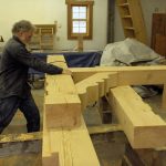 man and large wood beam